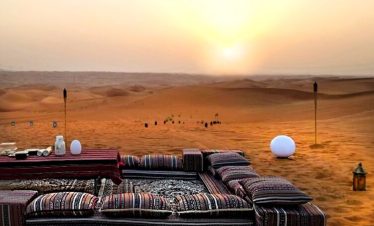 Golden desert dunes at dusk under evening sky